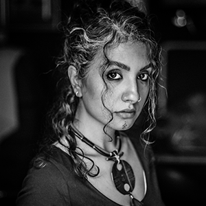 Portrait and bio of Negar Raam, a graphic designer and art crafter who blends imagery, silence, and material through poetic, handcrafted design works.